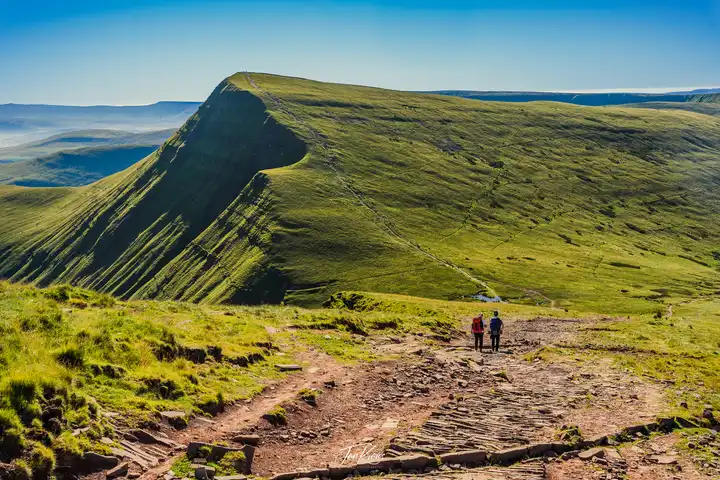 Two hikers on the trail at Brecon Beacons Mountains, Wales, UK