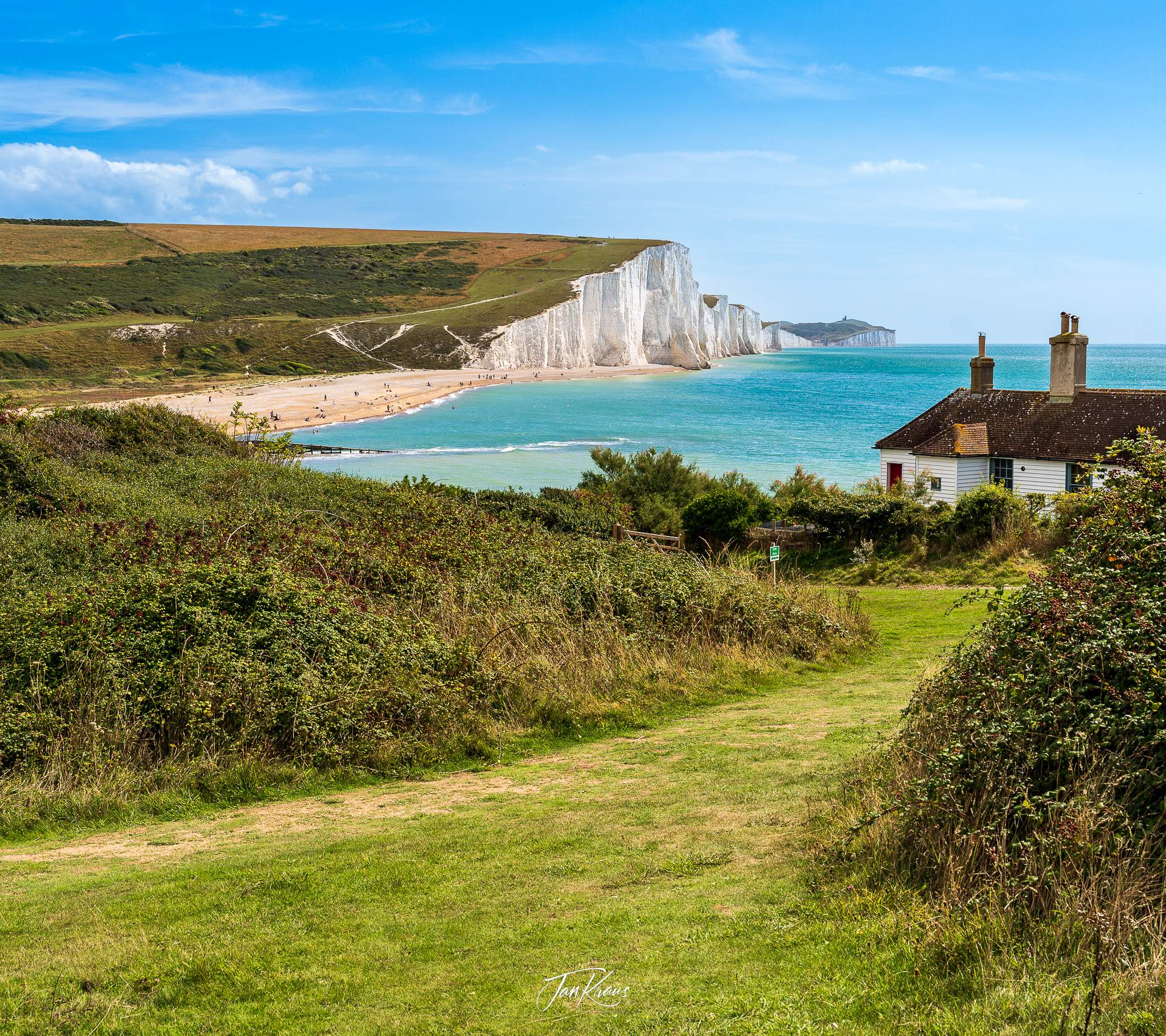 Coastguard Cottages with the stunning background of Cuckmere Haven at the Seven Sisters Walk, East Sussex, England, UK